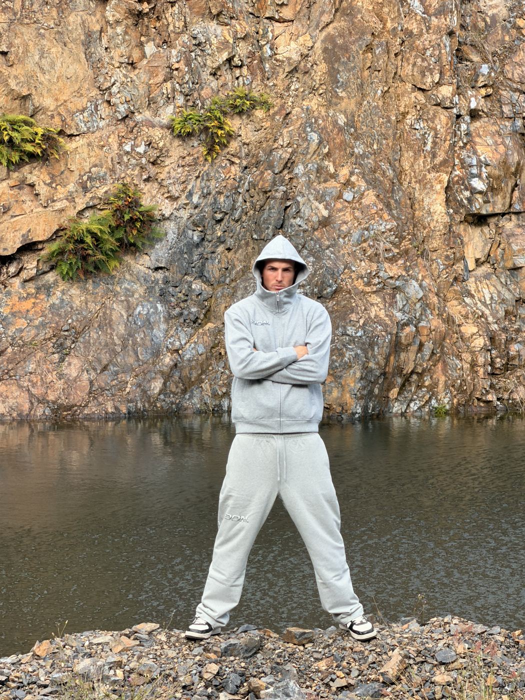Jayess in a grey hoodie by the water